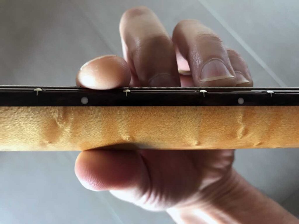 Photo d'un accord barré : pince du pouce. Vue guitariste